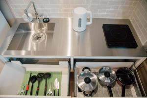 a kitchen with a sink and a stove with utensils at ホテル天使館 久茂地 -Tenshi-Kan- in Naha