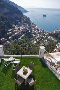 a balcony with a table and chairs and the ocean at Gresy Appartamento Suite in Positano
