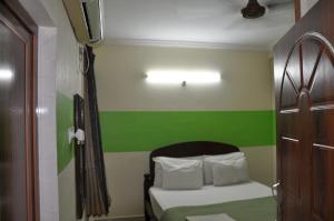 Un pequeño dormitorio con una pared verde y blanca en Nayath Serviced Apartments, en Tirupati