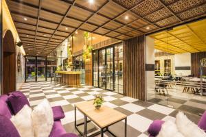 a lobby with purple furniture and a checkered floor at XQ Pattaya Hotel in Pattaya Central