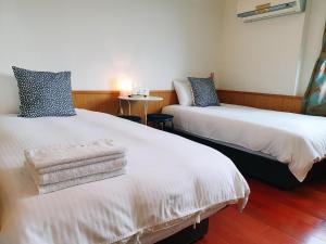 2 posti letto in camera con asciugamani di Kao Mama B&B a Jiufen