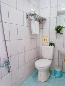 a white bathroom with a toilet and a sink at Kao Mama B&B in Jiufen