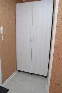 een witte kast in de hoek van een kamer bij 1 комнатная квартира в Щучинске in Shchūchīnsk