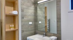 La salle de bains est pourvue d'un lavabo et d'un miroir. dans l'établissement Camp Waipu Cove, à Waipu