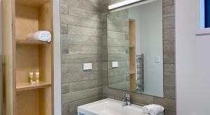 a bathroom with a sink and a mirror at Camp Waipu Cove in Waipu