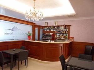 un restaurante con un bar con mesas y sillas en Hotel Belvedere, en Margherita di Savoia