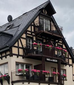 - un bâtiment noir et blanc avec des boîtes de fleurs et des balcons dans l'établissement Haus von Hoegen, à Cochem