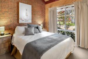a bedroom with a large bed and a brick wall at All Seasons Mansfield in Mansfield