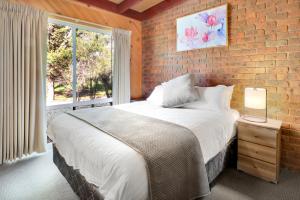 ein Schlafzimmer mit einem großen Bett und einer Ziegelwand in der Unterkunft All Seasons Mansfield in Mansfield