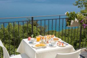 a table with breakfast food on top of a balcony at Diecidodici BoutiqueRooms in Sirolo
