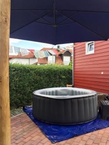 un grand parapluie noir assis sur une couverture bleue dans l'établissement Tinyhouse Bamberg, à Pettstadt