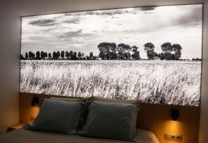 uma imagem a preto e branco de um campo atrás de uma cama em B&B Presende em Veurne