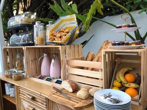 une étagère en bois avec du pain et d'autres aliments. dans l'établissement Hôtel Mademoiselle, à Juan-les-Pins