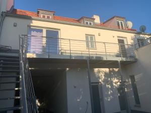 a large white building with a balcony and stairs at Maxima in Bamberg