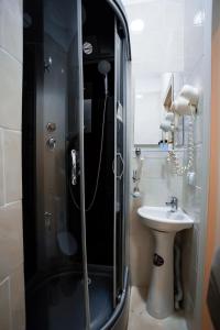 a bathroom with a shower and a sink at Versal Hotel in Astana