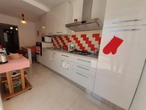 uma cozinha com armários brancos e uma toalha vermelha na parede em VILLA CASA SAGLIA em Malcesine