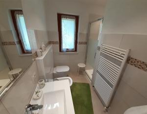 uma casa de banho branca com um lavatório e um WC em VILLA CASA SAGLIA em Malcesine