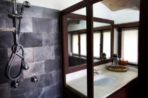 a bathroom with a sink and a shower with a mirror at Tiger Mountain Pokhara Lodge in Pokhara