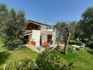 uma casa com uma pessoa sentada numa cadeira num quintal em VILLA CASA SAGLIA em Malcesine