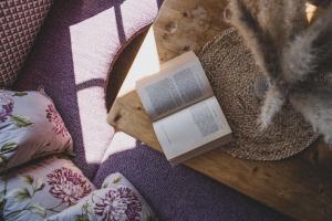un libro seduto su un tavolo accanto a un letto di Bergrose Hideaway a Strobl