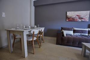 - un salon avec une table et un canapé dans l'établissement C.L.A. City Loux Apartment, à Alexandroúpolis