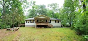 a white house with a porch and a yard at Ridge Retreat at Hearthstone Cabins and Camping - Pet Friendly in Helen