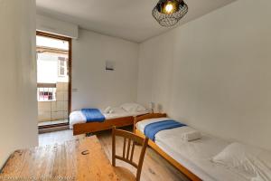 een kamer met 2 bedden, een tafel en een raam bij Le Vassé - Apartment 2 Bedrooms with terrace - pedestrian area in Annecy