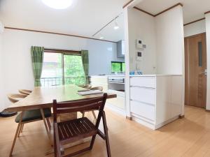 a kitchen with a wooden table and a wooden chair at Itsukaichi First Villa Hiroshima in Hiroshima