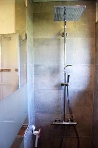 La salle de bains est pourvue d'une douche avec une lumière sur le mur. dans l'établissement daheim im hirschen, à Schönwald