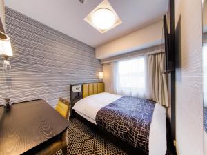 a hotel room with a bed and a window at APA Hotel Hiroshima-Ekimae Ohashi in Hiroshima