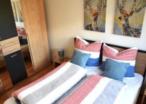 ein Schlafzimmer mit zwei Betten mit bunten Kissen in der Unterkunft daheim im hirschen in Schönwald + 17 Fotos
