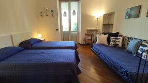 una camera con due letti e un divano in esso di Al Terra di Mare Appartamenti - "Garibaldi 80" a Levanto