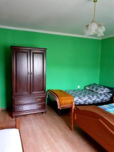 een groene kamer met 2 bedden en een kast bij Apartment Irena in Fužine