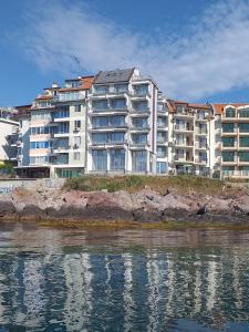 a large apartment building next to a body of water at HARMONY in Sozopol