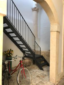 a red bike parked next to a staircase at Palazzo Cariddi Apartment in Nardò