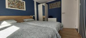 a bedroom with a bed and a blue wall at Seagarden by Valdemosa in De Haan