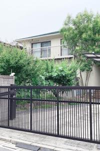 une clôture en fer noir devant une maison dans l'établissement Itsukaichi First Villa Hiroshima, à Hiroshima