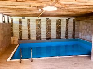a swimming pool in a room with a wooden ceiling at Hallstatt Dachstein Inn in Gosau