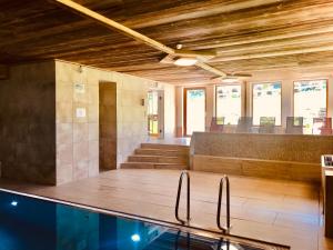 a swimming pool in a room with wooden ceilings at Hallstatt Dachstein Inn in Gosau