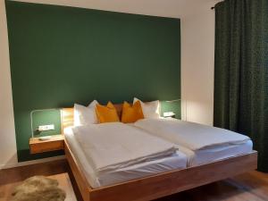- une chambre avec un grand lit et un mur vert dans l'établissement Ferienwohnung Judith, à Sillian