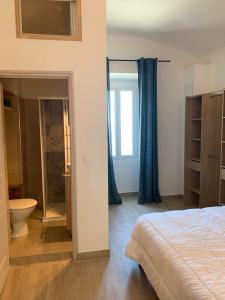 a bedroom with a bed and a bathroom with a shower at Casa Lisà in Sartène