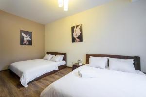 two beds in a room with white sheets at Аpartments in the center (Mytna square) in Lviv