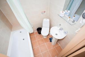 a bathroom with a toilet and a sink at SKYAruna in Astana +21 photos