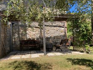 una panchina in un giardino con muro in pietra di Agriturismo Beata Vanna a Fabro