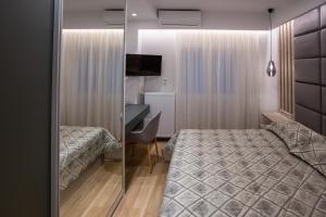 - une chambre avec 2 lits, un bureau et un miroir dans l'établissement Central Apartment Marianthe, à Ioannina