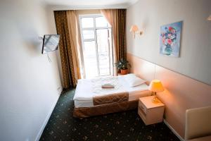 ein kleines Schlafzimmer mit einem Bett und einem Fenster in der Unterkunft SKYVersal in Astana