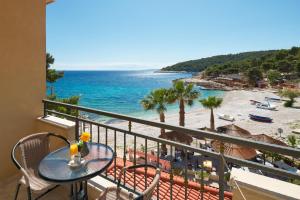 een balkon met een tafel en uitzicht op het strand bij Hotel Fortuna in Hvar