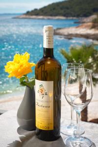 a bottle of wine sitting on a table next to a beach at Hotel Fortuna in Hvar