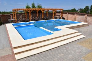 a swimming pool with a pergola and a swimming poolvisorvisorvisorvisor at Pensjonat Solis Sarbinowo in Sarbinowo