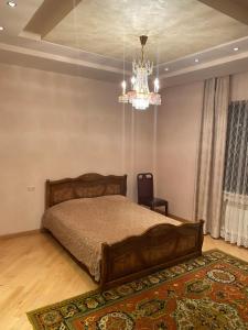 1 dormitorio con cama y lámpara de araña en House Abel en Tsaghkadzor
